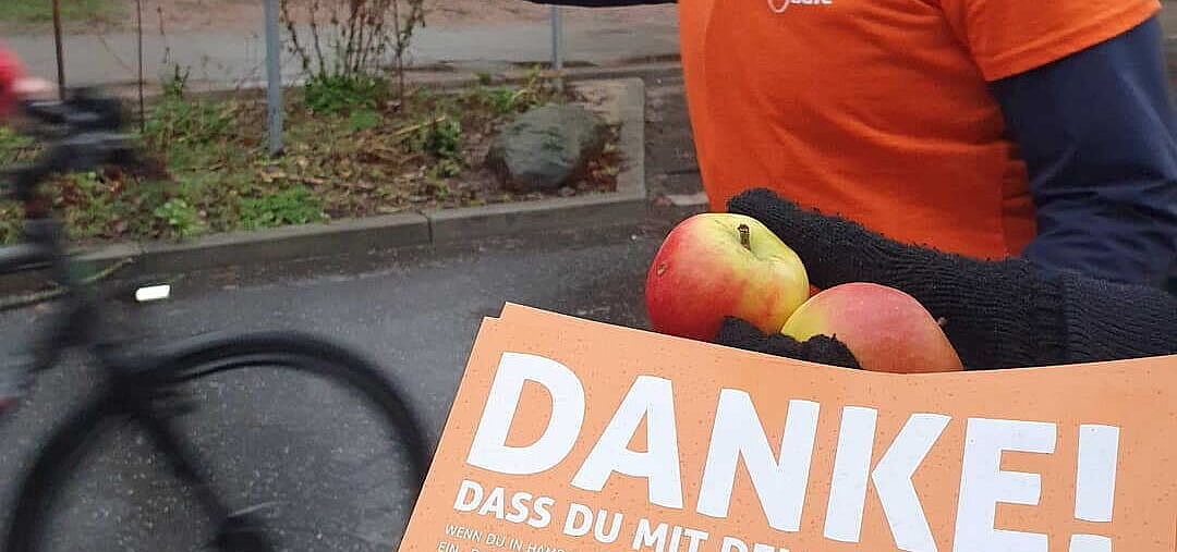 ADFC-Aktive bedanken sich bei Radfahrenden im Winter mit Äpfeln fürs Radfahren. 
