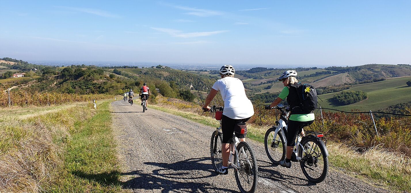 Zwei Frauen auf Fahrrädern in hügeliger Landschaft