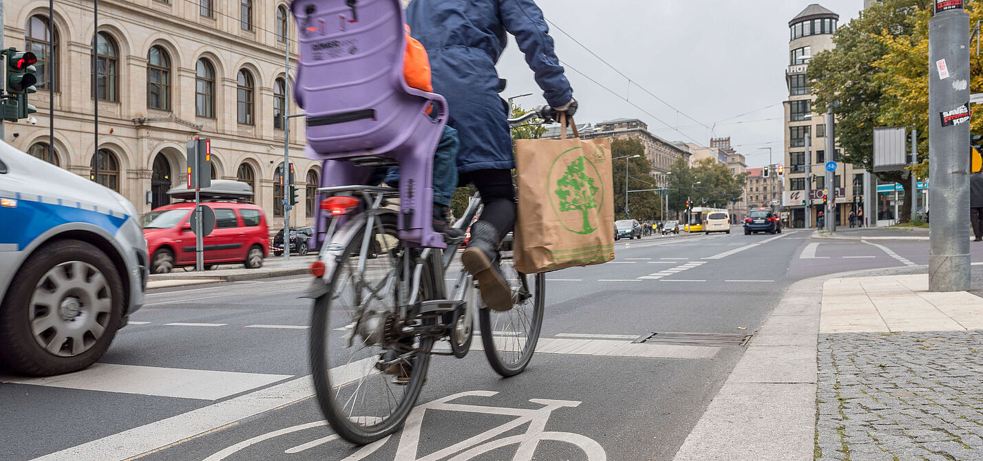 Frau mit Kind auf dem Rad in der Stadt unterwegs